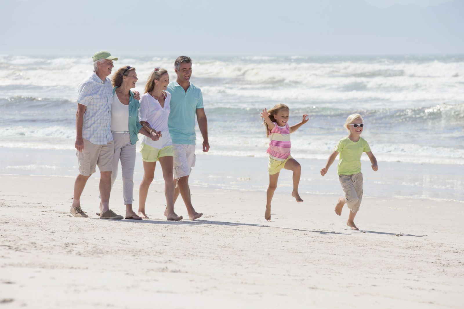 Three generations of a family walking together on the beach
